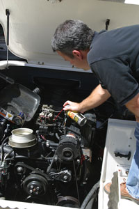Man spraying starting fluid into carburetor