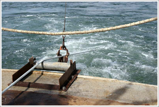 Anchor line led over roller at stern