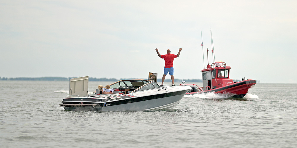 person on a boat flagging down a boat us tow boat