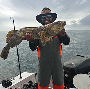 Miguel Maldonado holding up large lingcod