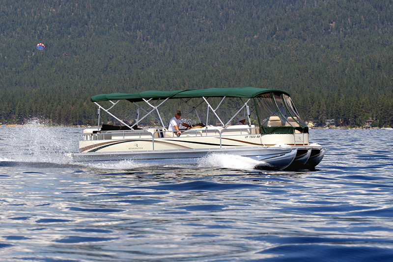 person driving a pontoon boat