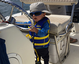 Young toddler at helm of powerboat