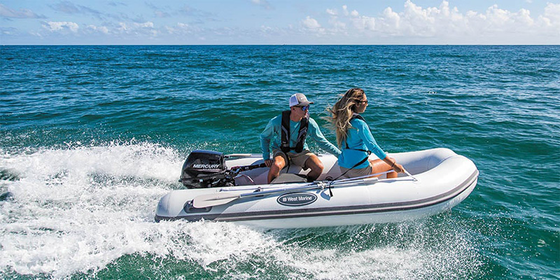 Man and woman on an inflatable boat with outboard motor