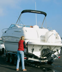 Person checking the tension on the tiedown straps after pulling out the boat