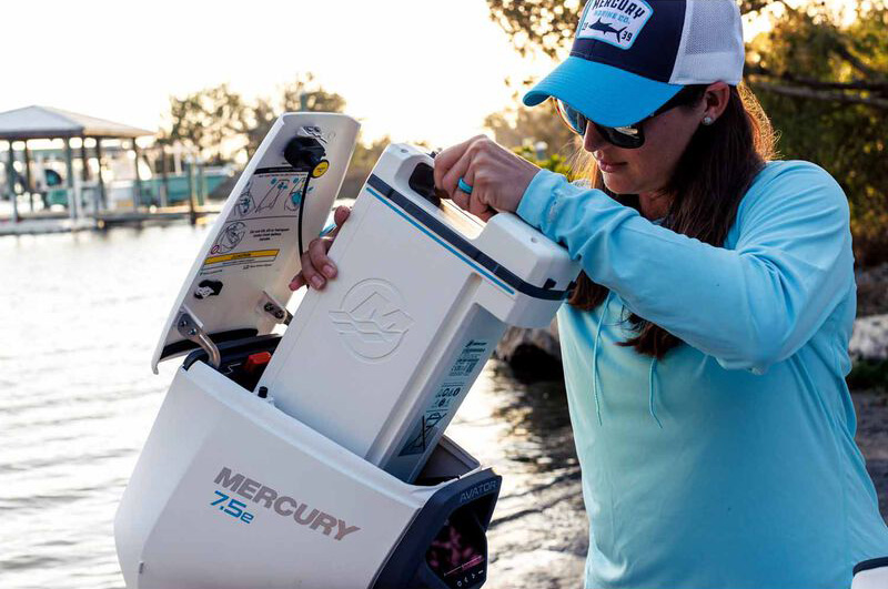 person installing a battery in an electric outboard motor setup