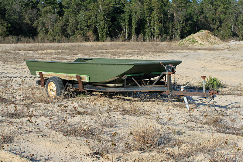 *Green Jon boat on trailer in field