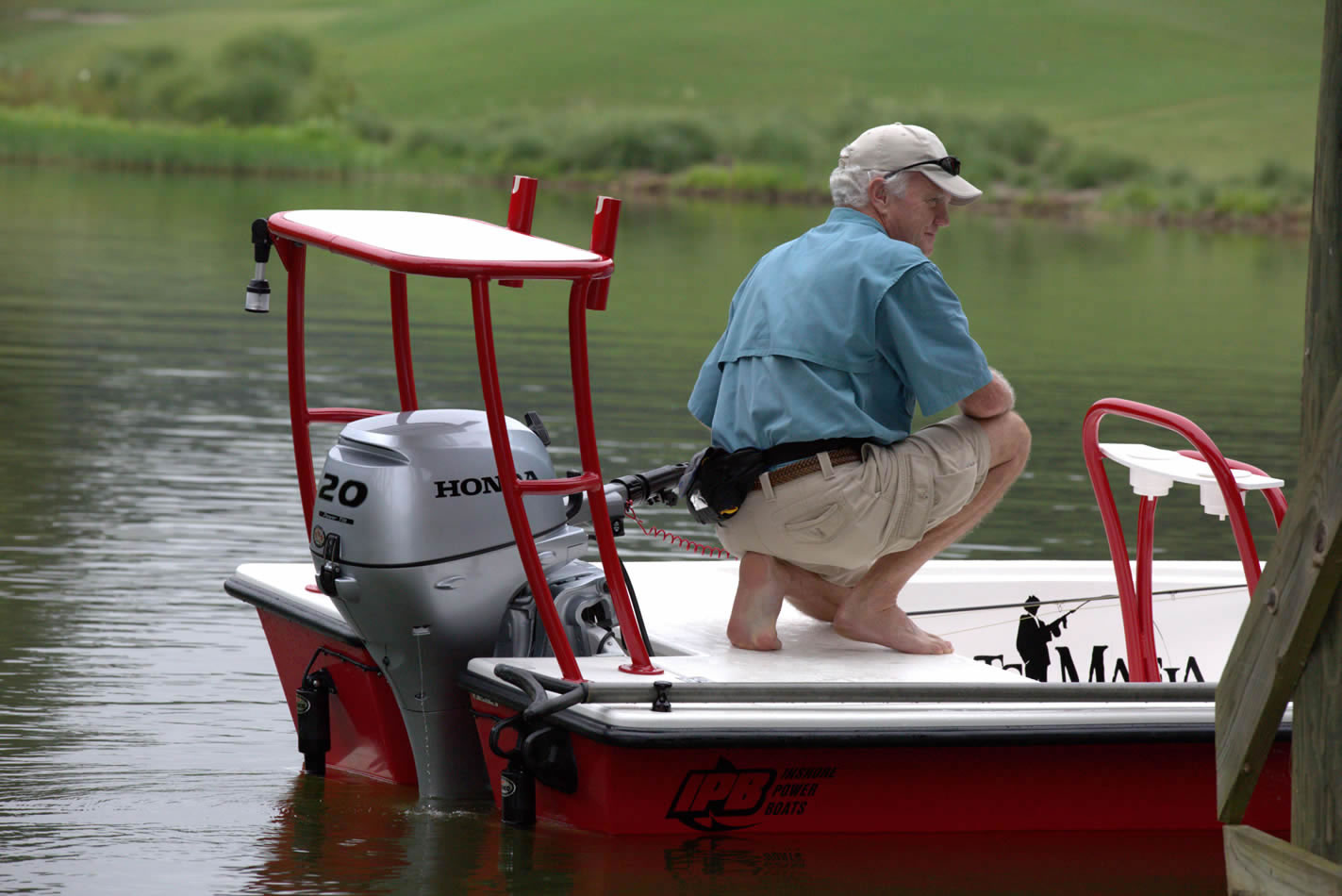 a man on a fishing boat with a 20 horsepower Honda outboard motor attached