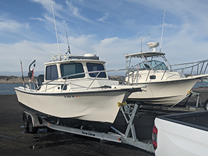 Two boats on their trailers in parking lot