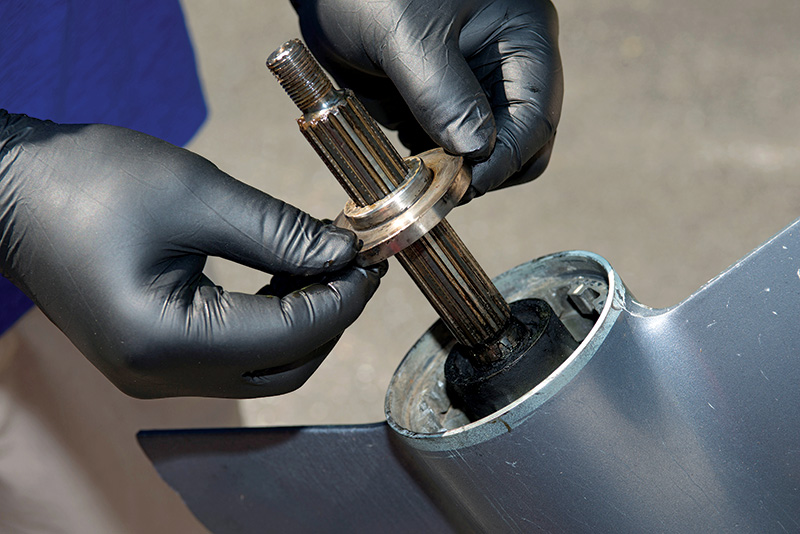 person removing the thrust washer from the prop shaft